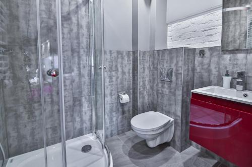 a bathroom with a toilet sink and a shower at Kamienica Morska Gdynia in Gdynia