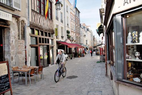een persoon die op een fiets door een straat rijdt bij Porte Bourgogne in Orléans