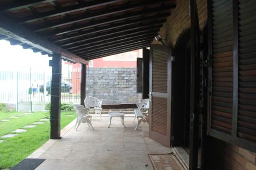 a patio with two chairs and a table on it at RESONAMUH - Hostel in São Pedro da Aldeia