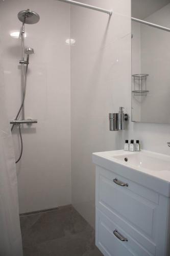 a white bathroom with a sink and a shower at B&B Mondriaan in Amsterdam