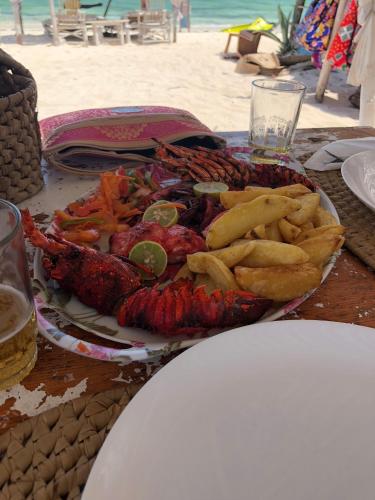 a plate of food on a table next to the beach at BeB Sardegna2 Anjumasa village in Watamu