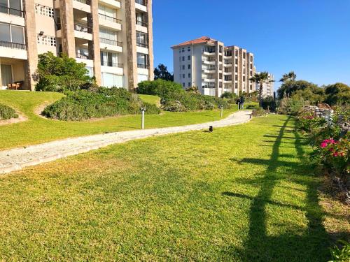 a grassy field with buildings in the background at Tramonto Sul Mare en Serena Golf in La Serena