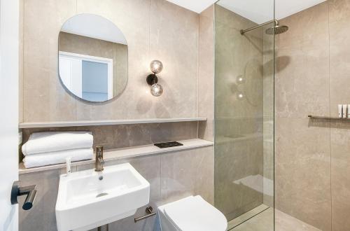 a bathroom with a sink and a mirror and a shower at Nova Kiama in Kiama