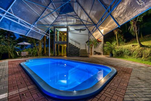 a large blue pool in front of a house at Hotel Casa Conley Del Mar in Puerto Viejo