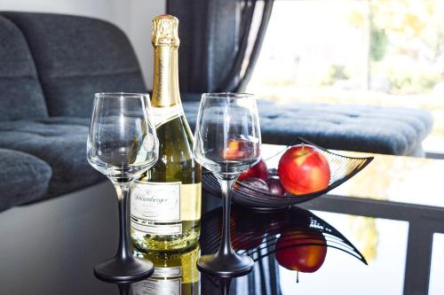 uma garrafa de vinho e dois copos de vinho numa mesa em Brand New Apartment, Top Location-Near VIC/Danube em Viena