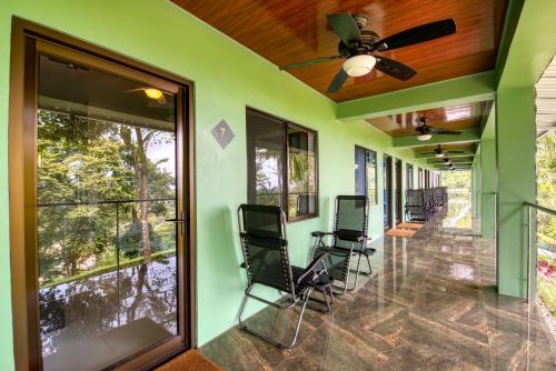 a screened porch with chairs and a ceiling fan at Hotel Casa Conley Del Mar in Puerto Viejo