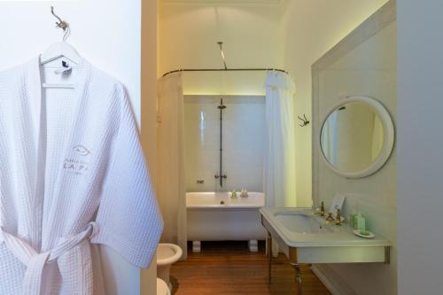 a white bathroom with a sink and a bath tub at Estancia La Paz Hotel in Ascochinga