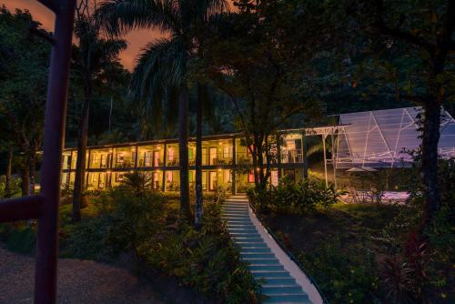 a building lit up at night with palm trees at Hotel Casa Conley Del Mar in Puerto Viejo