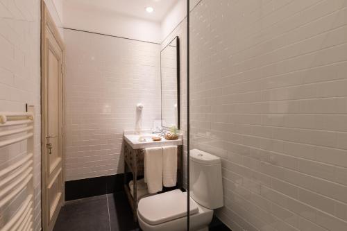 a white bathroom with a toilet and a sink at Estancia La Paz Hotel in Ascochinga