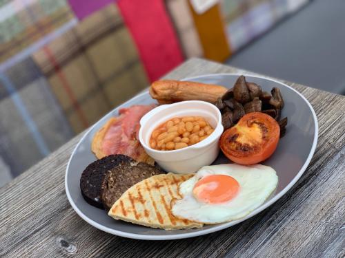 a plate of breakfast food with eggs sausage and beans at Abbey Guest House in Peterhead