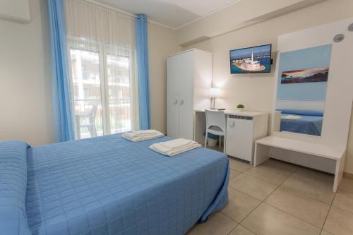 um quarto com uma cama azul e uma secretária em I Granai Messina em Messina