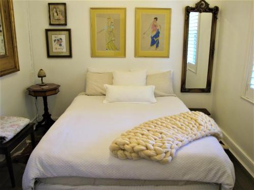 a bedroom with a white bed with a blanket on it at Apple Tree Cottage in Mittagong