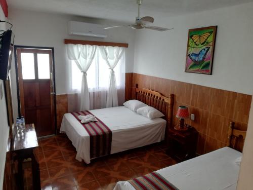 a bedroom with two beds and a window at Hotel La Union in Flores