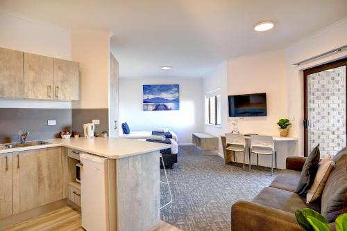 a kitchen and living room with a couch and a table at Limani Port Lincoln in Port Lincoln