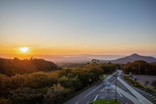 an empty road with the sunset in the background at ITADAKI Daisen 大山参道ホテル頂 in Daisen