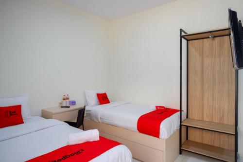 a hotel room with two beds and a tv at RedDoorz near Alun Alun Kudus 2 in Kudus