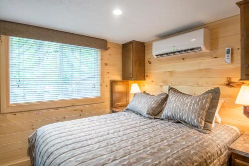 a bedroom with a bed and a window at Williamsburg Camping Resort 38 ft. Park Model 5 in Croaker