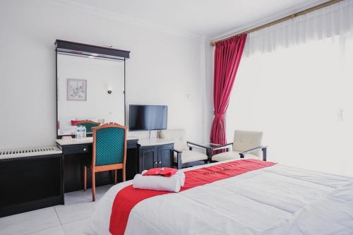 a bedroom with a bed and a desk with a computer at RedDoorz Plus near Pelabuhan Merak in Cilegon