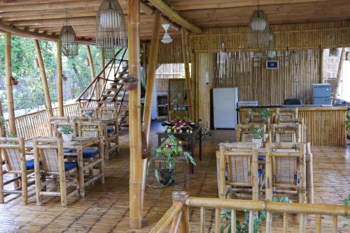 Habitación con mesas, sillas y nevera. en Seri Resort Gili Meno - Adults Only, en Gili Meno