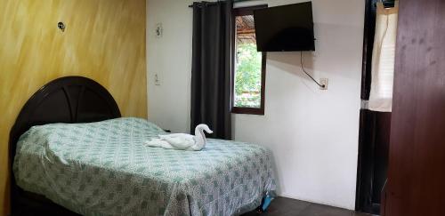 a bedroom with a bed with a stuffed swan on it at Saak Luúm Ruta Puuc in Sacalum