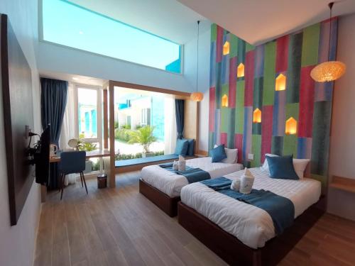 a hotel room with two beds and a window at เดอะชาลี The Charlie in Nan