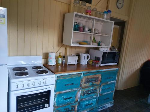 a kitchen with a stove and a microwave at Golden Mt Rest off Pepperina Lane in Mount Morgan