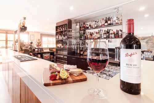 a bottle of wine sitting on a counter with a glass at Best Western Plus Buckingham International in Moorabbin