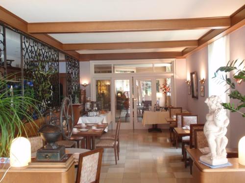 a dining room with tables and chairs in a restaurant at Hotel du Parc in Diekirch