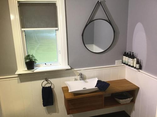 a bathroom with a sink, toilet and mirror at Harrison House in Strahan