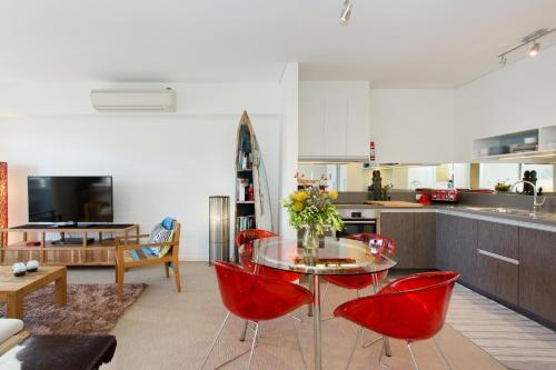 a kitchen with a table and red chairs in a room at Seabreeze - Coastal Living in Fremantle