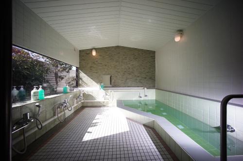 a large bathroom with a tub and a sink at 館林グランドホテル in Tatebayashi