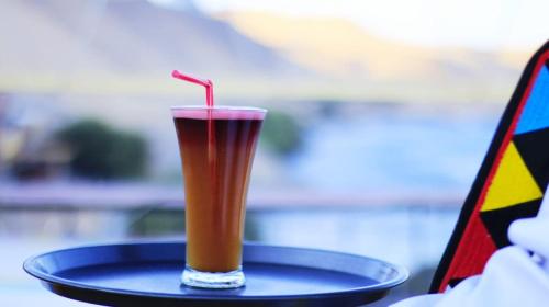 a drink sitting on a plate on a table at Onaty Ka Guest House in Aswan