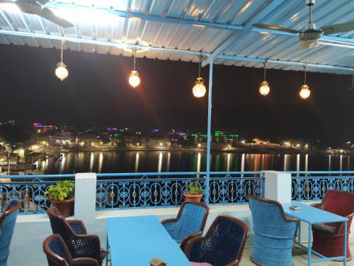 a patio with tables and chairs and a view of the water at Hotel Bharatpur Palace in Pushkar