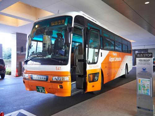 東京にある相鉄グランドフレッサ 東京ベイ有明の建物内に停車するオレンジ白バス