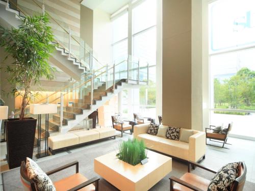 a lobby with couches and chairs and a staircase at Sotetsu Grand Fresa Tokyo-Bay Ariake in Tokyo