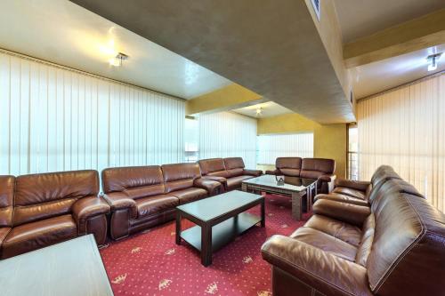 ein Wartezimmer mit braunen Ledersofas und einem Tisch in der Unterkunft Merian Palace Hotel in Stara Sagora