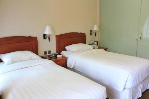 سرير أو أسرّة في غرفة في Thong's Inn Hotel Kualanamu