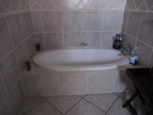 a bath tub in a tiled bathroom at faces guesthouse in Bethlehem