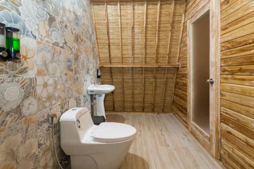 a bathroom with a toilet and a sink at The Dewi Sun Sun Nusa Penida in Nusa Penida