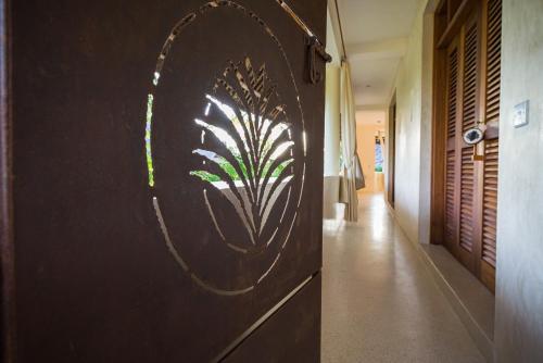 a wall with a painting of a plant on it at Palm Garden ECO Boutique Hotel No Kids under 12 in Watamu