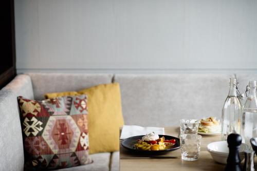a table with a plate of food and a bottle at Hotel Schwarzschmied in Lana