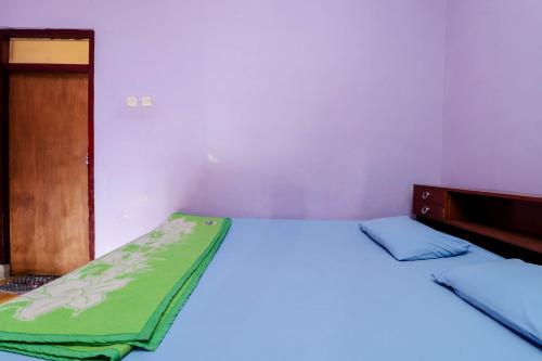 Postel nebo postele na pokoji v ubytování Penginapan Sedyo Rahayu