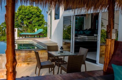 une terrasse avec une table, des chaises et une piscine dans l'établissement Horizon Luxury Pool Villas Koh Tao, à Koh Tao