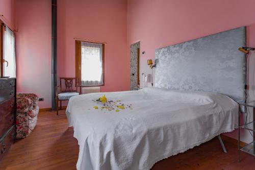 a pink bedroom with a bed with flowers on it at La Villa delle Rose near Venice in Trebaseleghe