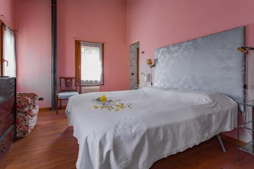 TrebaselegheにあるLa Villa delle Rose near Veniceのピンクのベッドルーム(花の飾られたベッド付)