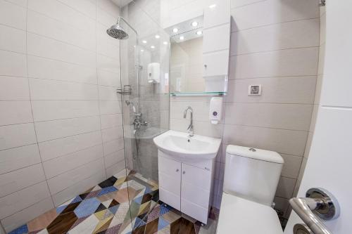 a white bathroom with a sink and a toilet at Sofia Rococo Life Apartments in Sofia