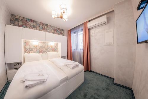 a bedroom with a large white bed and a television at Sofia Rococo Life Apartments in Sofia