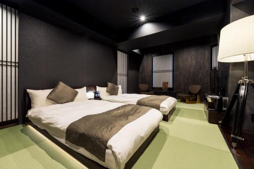 two beds in a room with green floors at PROSTYLE Ryokan Yokohama Bashamichi in Yokohama