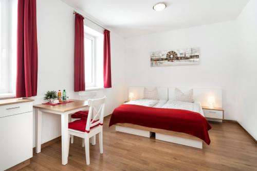 een slaapkamer met een bed, een tafel en een bureau bij Pension Gschaider in Payerbach