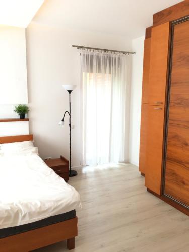 a bedroom with a bed and a large window at Apartament Willa Port in Ostróda